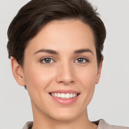 Joyful white young-adult female with short  brown hair and brown eyes