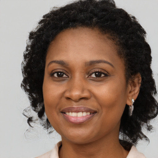Joyful black adult female with medium  black hair and brown eyes