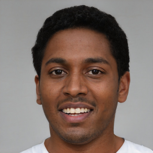 Joyful black young-adult male with short  black hair and brown eyes