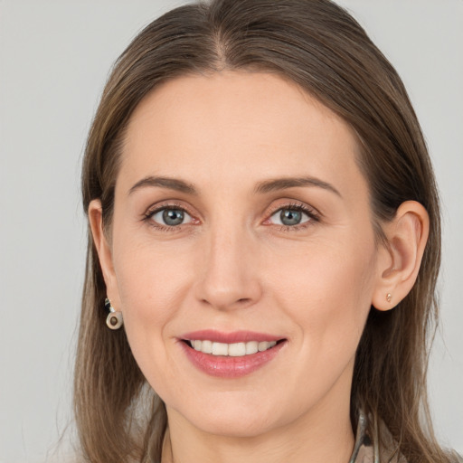 Joyful white young-adult female with long  brown hair and grey eyes