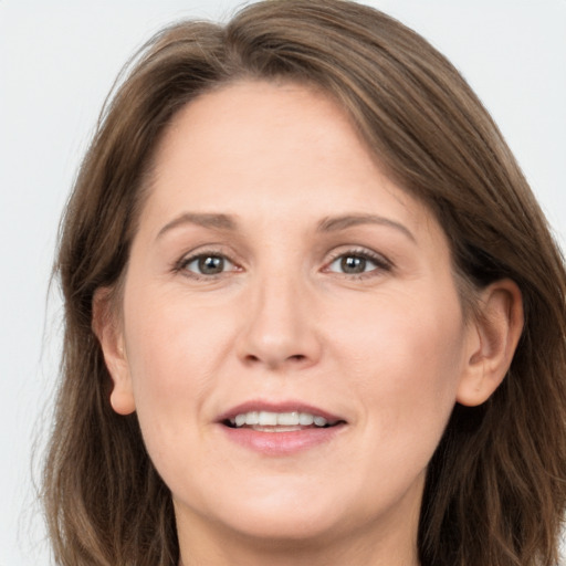 Joyful white adult female with long  brown hair and grey eyes