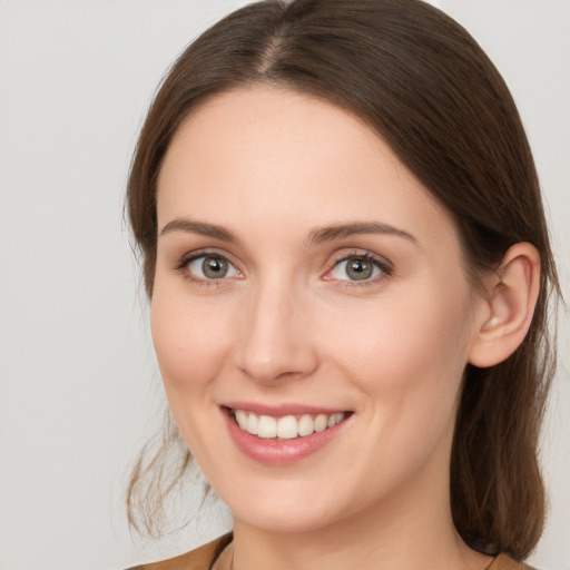 Joyful white young-adult female with medium  brown hair and grey eyes