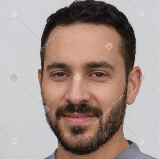 Joyful white young-adult male with short  black hair and brown eyes