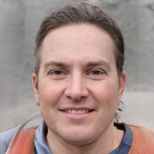 Joyful white adult male with short  brown hair and grey eyes