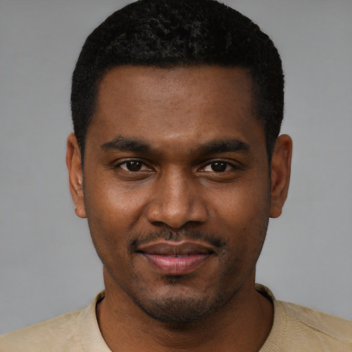 Joyful black young-adult male with short  black hair and brown eyes