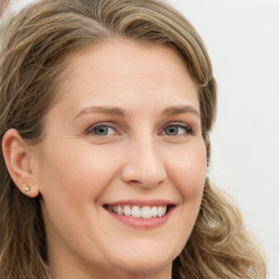 Joyful white young-adult female with long  brown hair and green eyes