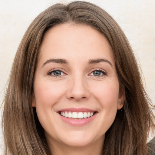 Joyful white young-adult female with long  brown hair and green eyes