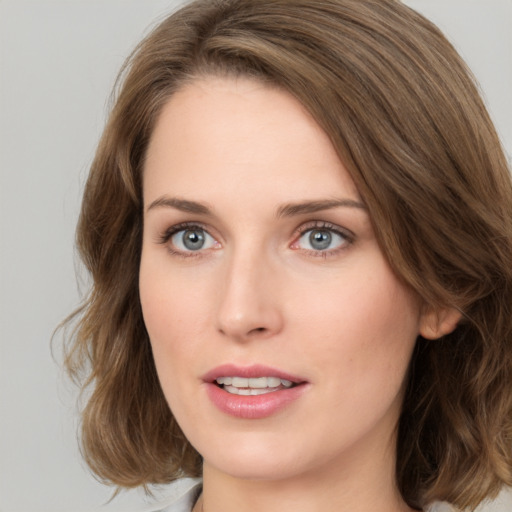 Joyful white young-adult female with medium  brown hair and green eyes