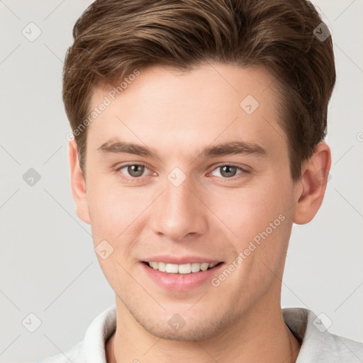 Joyful white young-adult male with short  brown hair and grey eyes