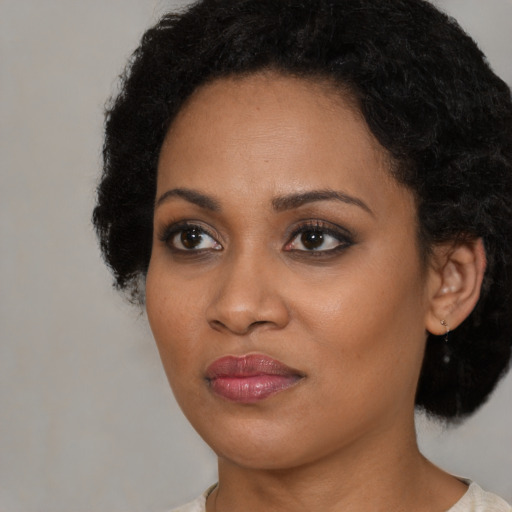 Joyful black young-adult female with short  black hair and brown eyes
