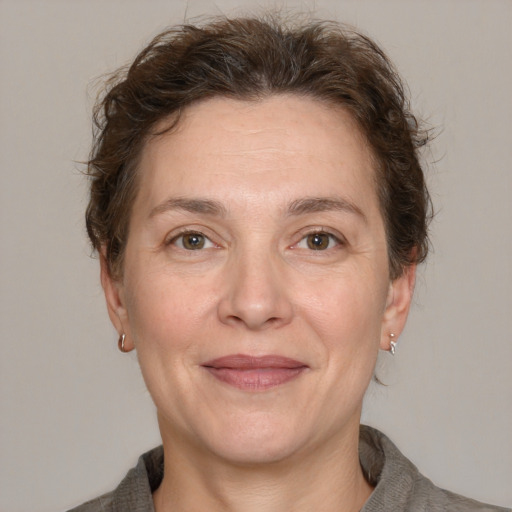 Joyful white adult female with medium  brown hair and grey eyes