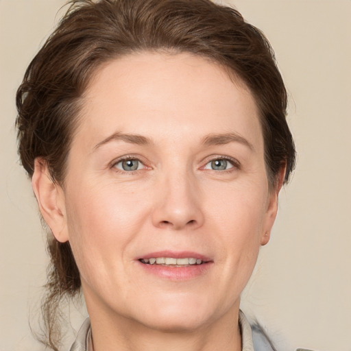 Joyful white adult female with medium  brown hair and grey eyes