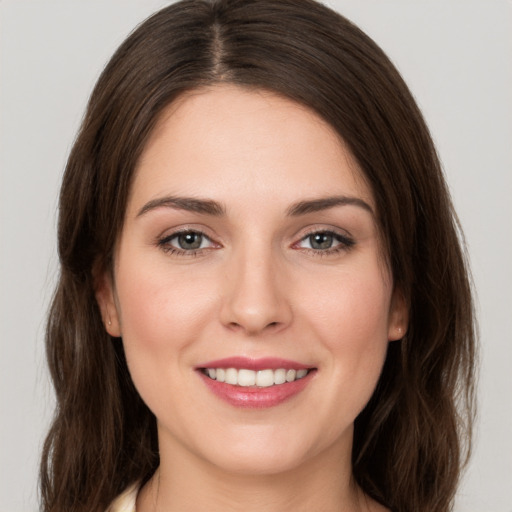 Joyful white young-adult female with medium  brown hair and grey eyes