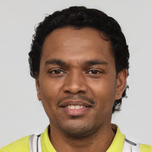 Joyful black young-adult male with short  black hair and brown eyes