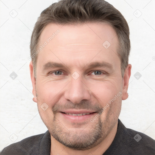 Joyful white adult male with short  brown hair and grey eyes