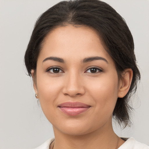 Joyful latino young-adult female with medium  brown hair and brown eyes