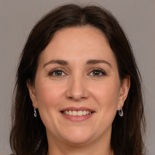 Joyful white adult female with long  brown hair and brown eyes