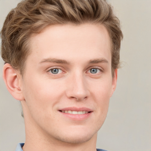 Joyful white young-adult male with short  brown hair and blue eyes