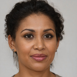 Joyful black adult female with medium  brown hair and brown eyes