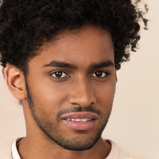 Joyful black young-adult male with short  brown hair and brown eyes