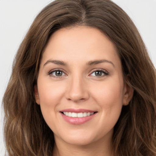 Joyful white young-adult female with long  brown hair and green eyes