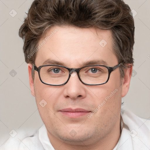 Joyful white adult male with short  brown hair and blue eyes