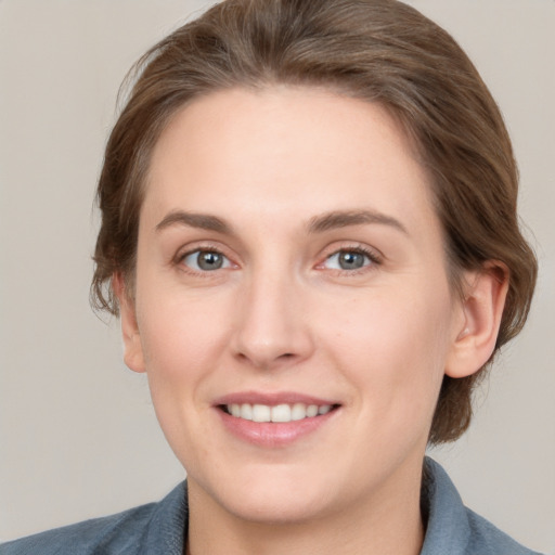 Joyful white young-adult female with medium  brown hair and grey eyes