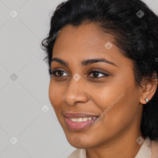 Joyful black young-adult female with long  brown hair and brown eyes