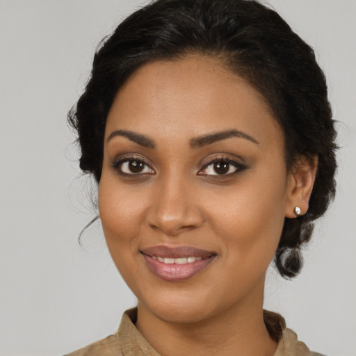 Joyful black young-adult female with long  brown hair and brown eyes