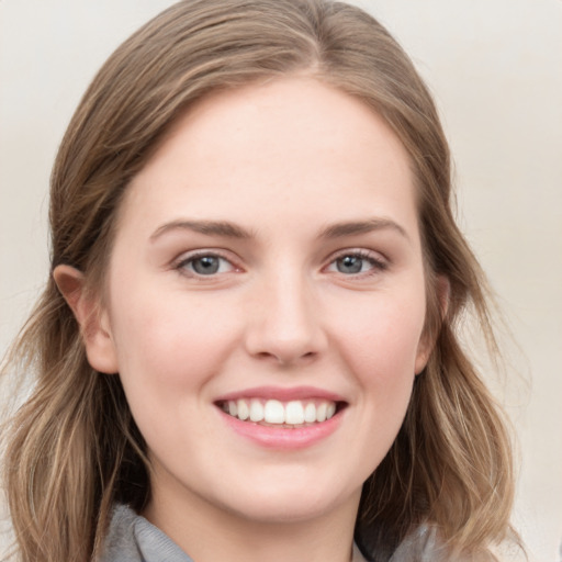 Joyful white young-adult female with long  brown hair and grey eyes