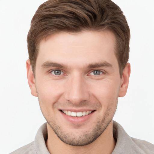 Joyful white young-adult male with short  brown hair and grey eyes