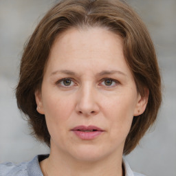 Joyful white adult female with medium  brown hair and grey eyes