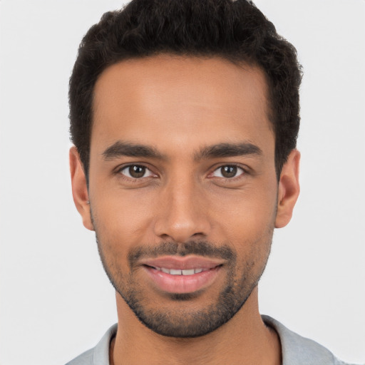 Joyful latino young-adult male with short  black hair and brown eyes