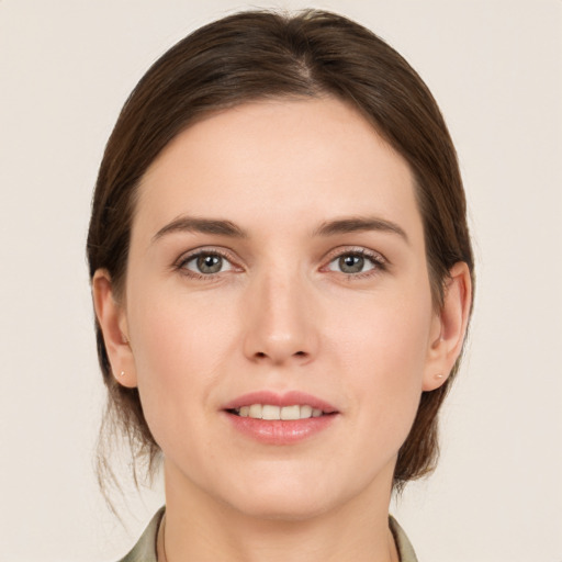 Joyful white young-adult female with medium  brown hair and grey eyes