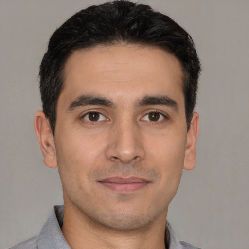 Joyful white young-adult male with short  black hair and brown eyes