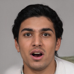 Joyful latino young-adult male with short  black hair and brown eyes