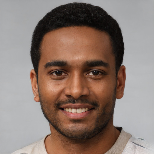 Joyful black young-adult male with short  black hair and brown eyes