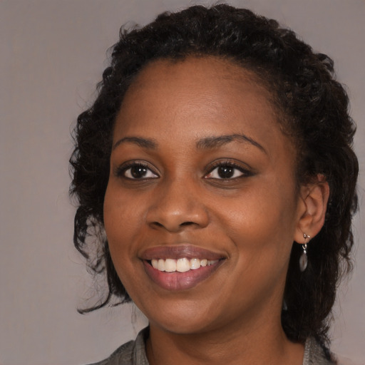Joyful black young-adult female with medium  brown hair and brown eyes