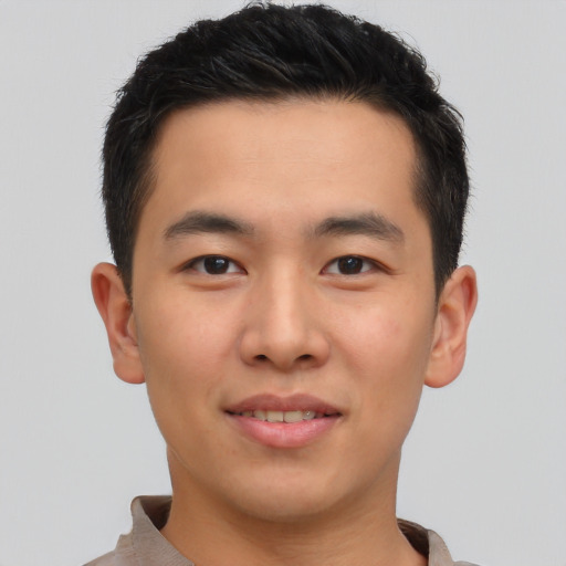 Joyful asian young-adult male with short  brown hair and brown eyes