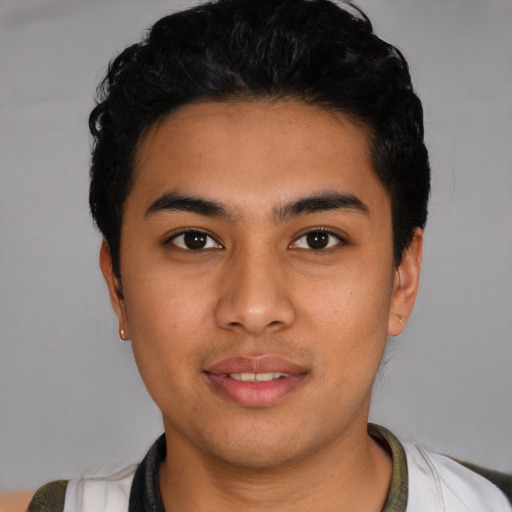 Joyful latino young-adult male with short  black hair and brown eyes