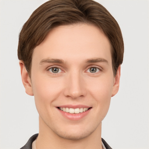 Joyful white young-adult male with short  brown hair and grey eyes