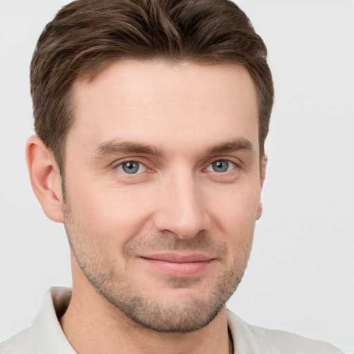 Joyful white young-adult male with short  brown hair and grey eyes