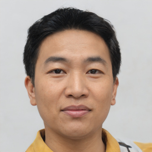 Joyful asian young-adult male with short  black hair and brown eyes