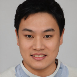 Joyful asian young-adult male with short  black hair and brown eyes