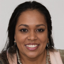 Joyful black young-adult female with long  brown hair and brown eyes