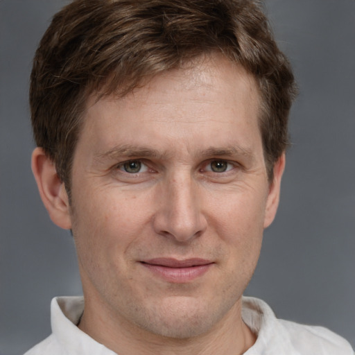 Joyful white adult male with short  brown hair and grey eyes