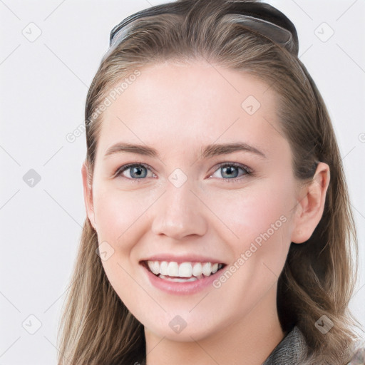 Joyful white young-adult female with long  brown hair and blue eyes