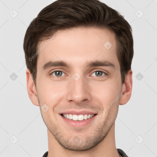 Joyful white young-adult male with short  brown hair and grey eyes