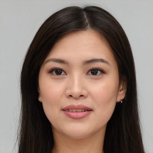 Joyful asian young-adult female with long  brown hair and brown eyes