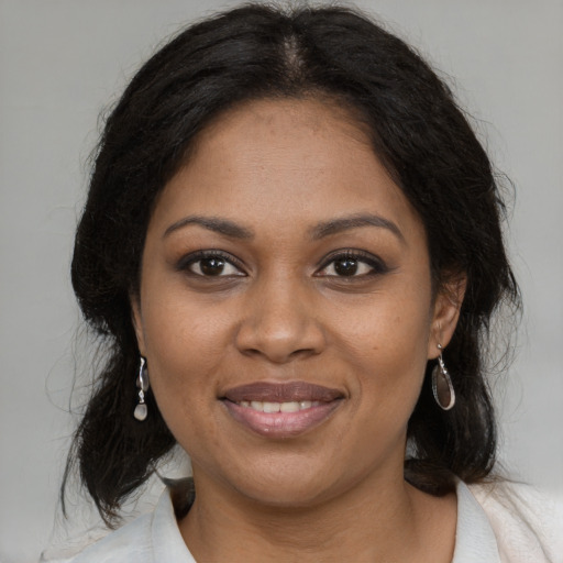 Joyful black adult female with medium  brown hair and brown eyes